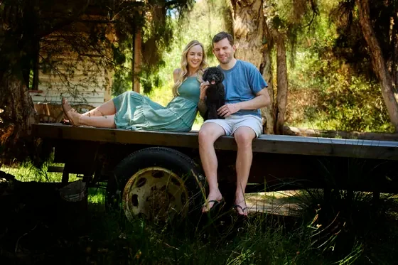 Couple in dusty blue and denim seated on the flatbed truck with their dog at Premier Studio