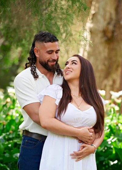 Couple in white and denim embracing among the arum lilies at Premier Studio