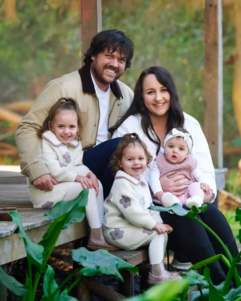 Family of five in cream knits and dusty pink seated among the arum lilies at Premier Studio