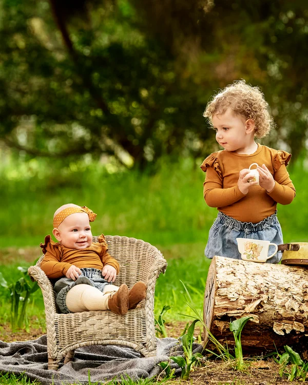 A large family photographed outdoors wearing bold colours
