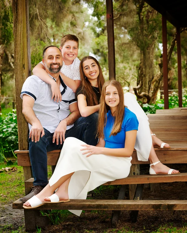 A large family photographed outdoors wearing white and denim