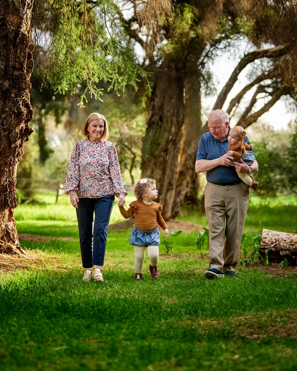 A large family photographed outdoors wearing bold colours