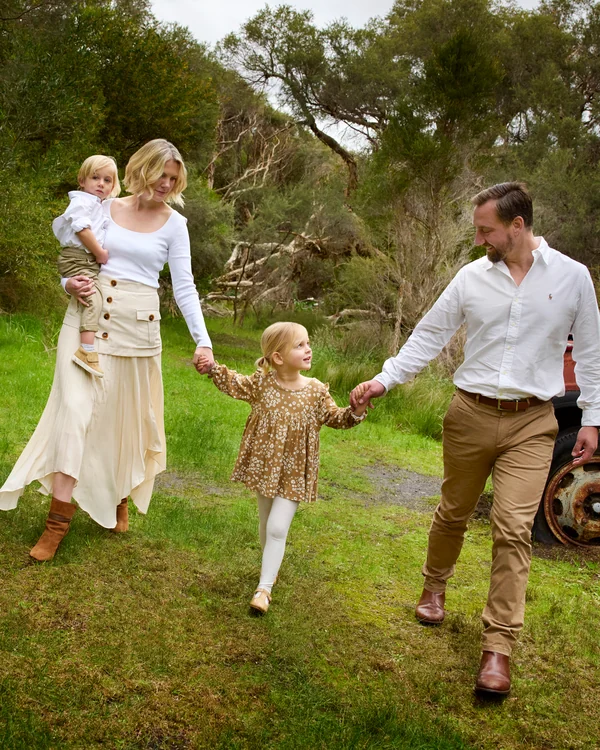 A large family photographed outdoors wearing white and denim
