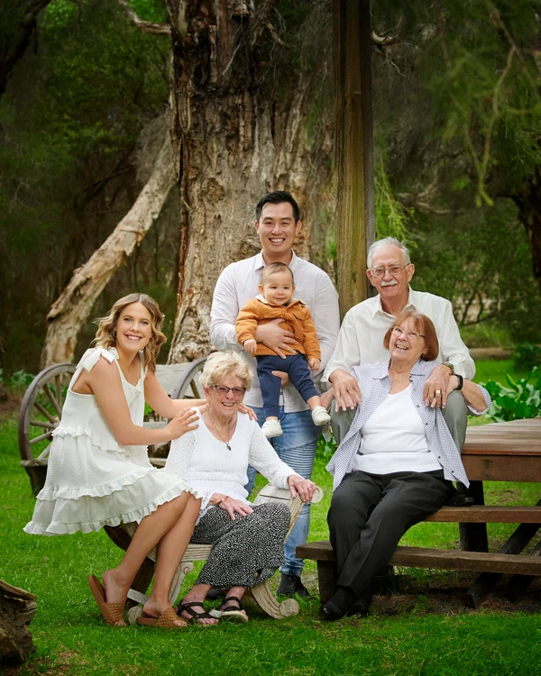 A large family photographed outdoors wearing white and denim