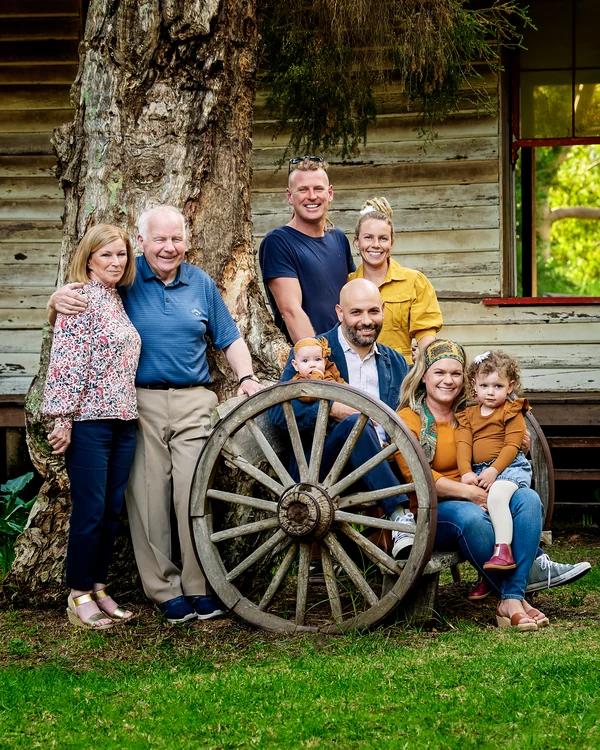 A large family photographed outdoors wearing bold colours