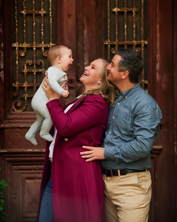 A large family photographed outdoors wearing blues, greens and tan