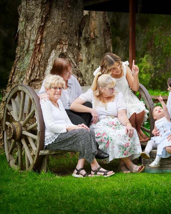 A large family photographed outdoors wearing white and denim