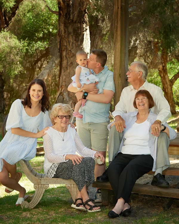 A large family photographed outdoors wearing white and denim