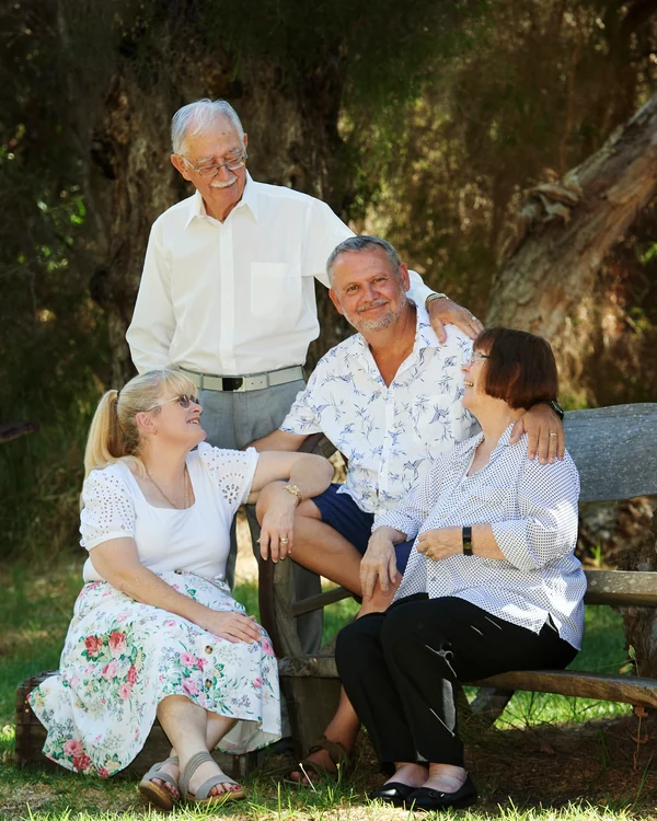 A large family photographed outdoors wearing white and denim