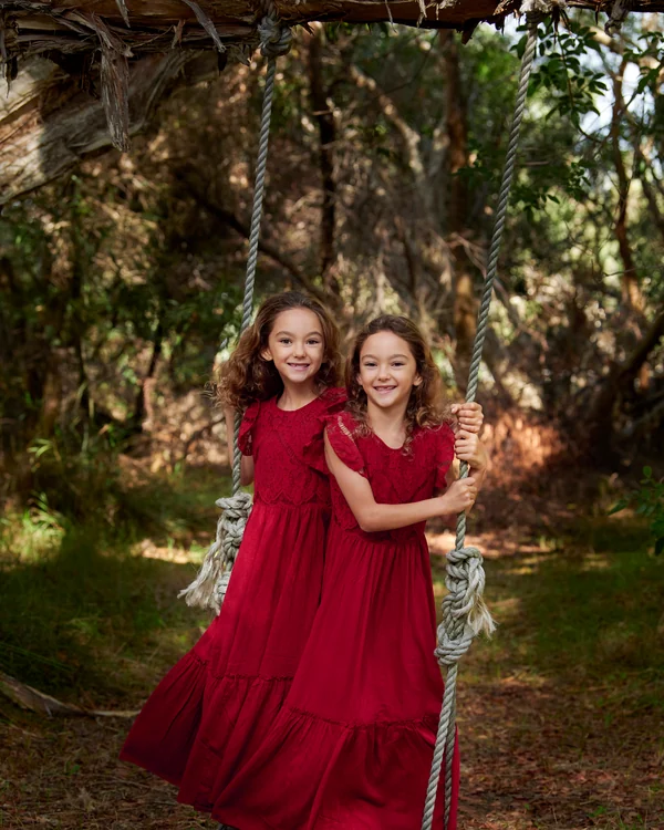 A large family photographed outdoors wearing bold colours
