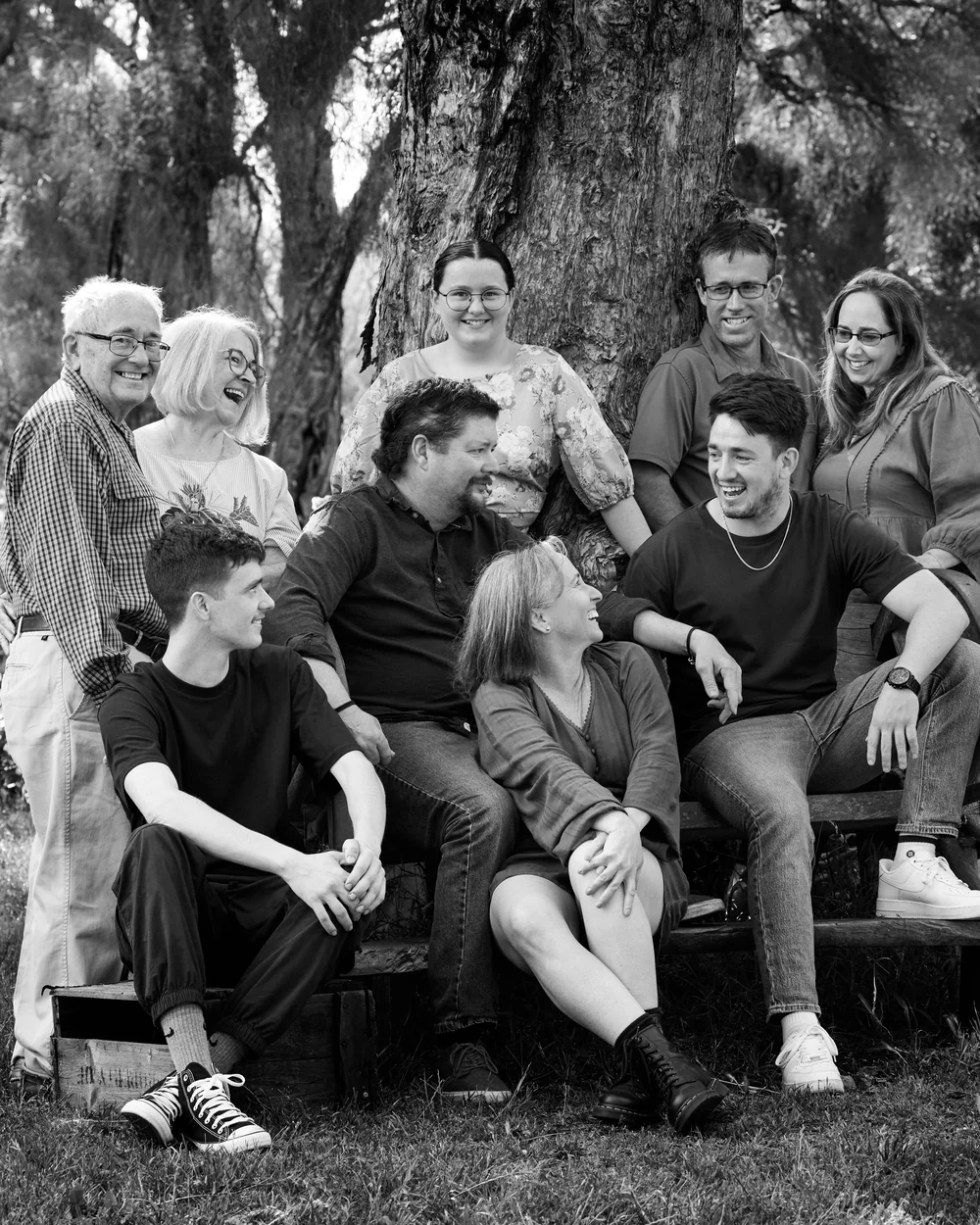A large family photographed outdoors wearing bold colours
