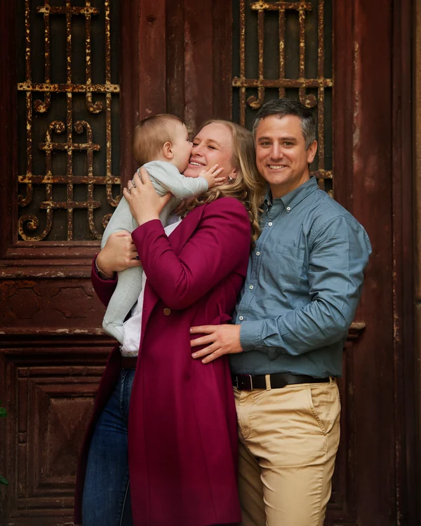A large family photographed outdoors wearing bold colours