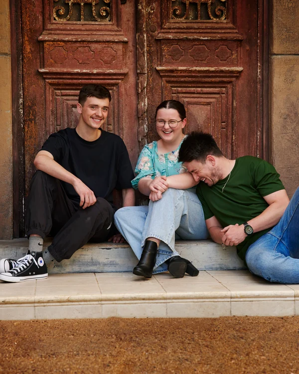 A large family photographed outdoors wearing bold colours