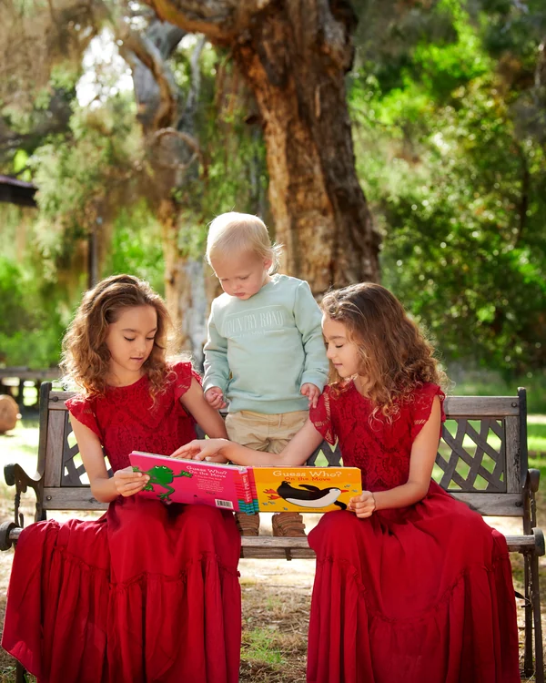 A large family photographed outdoors wearing bold colours