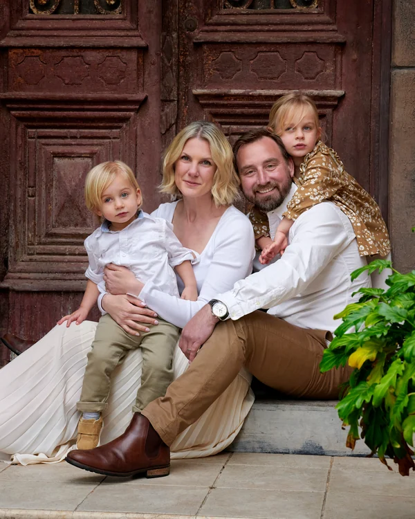 A large family photographed outdoors wearing white and denim