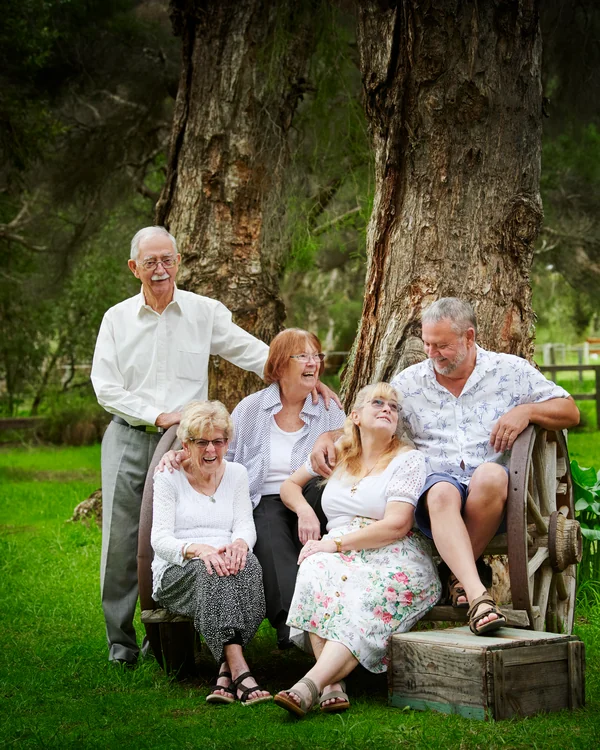 A large family photographed outdoors wearing white and denim
