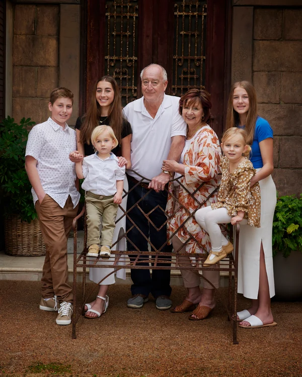 A large family photographed outdoors wearing white and denim